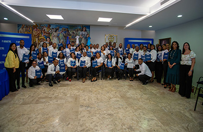 Maestros posan mostrando sus certificaciones acompañados por representantes de la Escuela de Idiomas de la Universidad APEC
